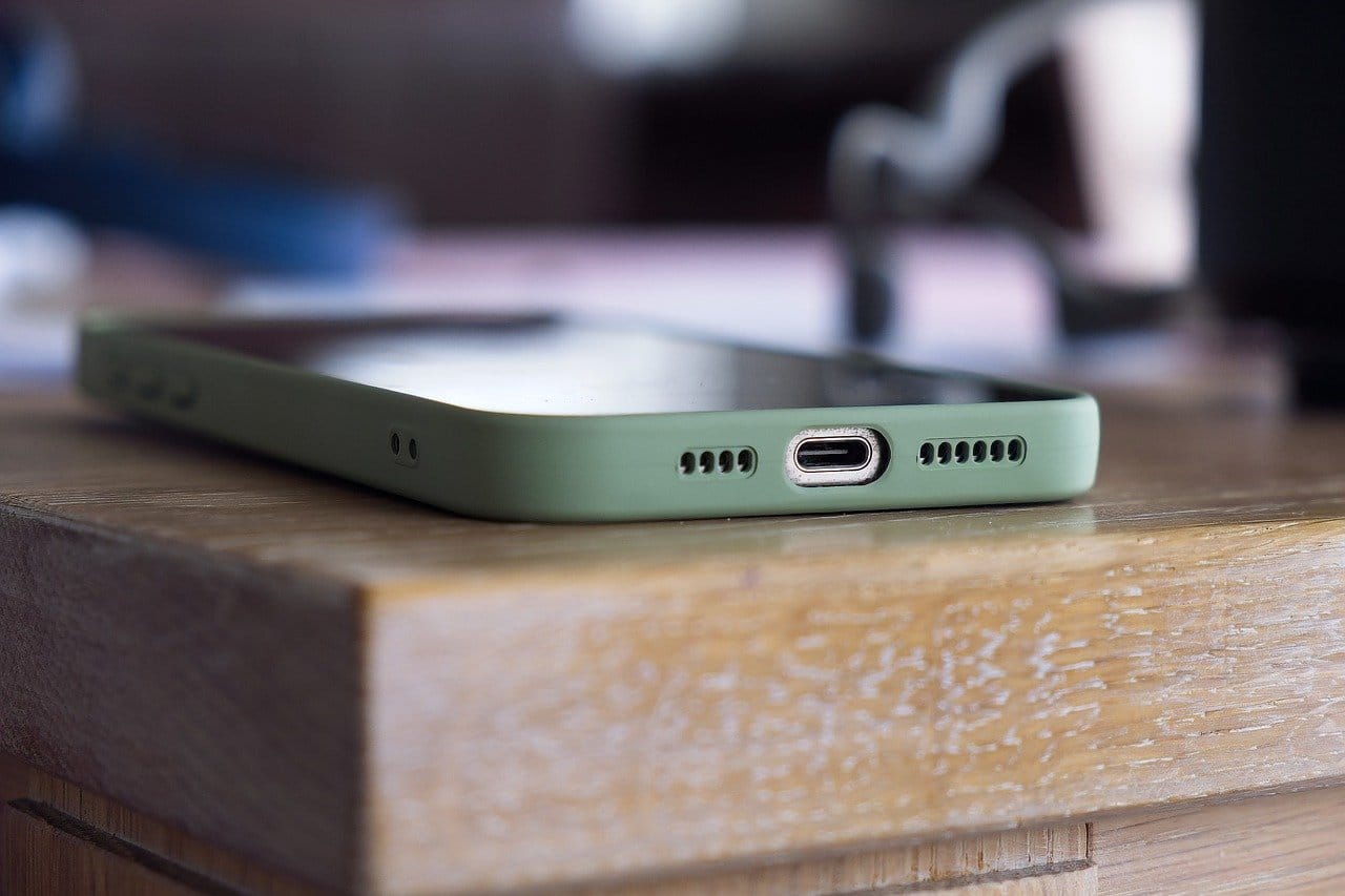 An iPhone on a wooden table displaying the battery charge socket